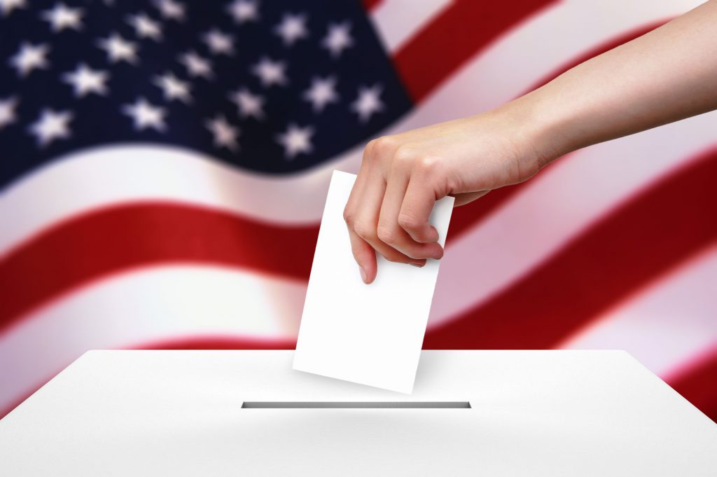 hand with ballot and box on flag of usa