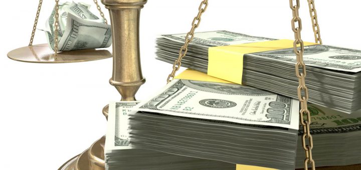 An old school bronze justice scale with stacks of us dollar money on one side and a few crumpled notes on the other representing the inequality in the income gap an isolated white background