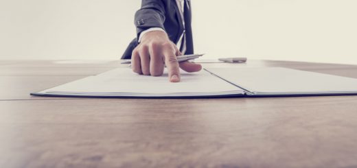 Front view of employer pointing to a contract where to sign, vintage effect toned image.