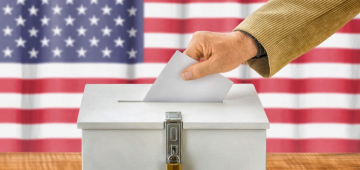 Man putting a ballot into a voting box - USA