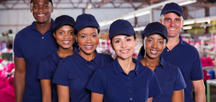 group of happy clothing factory workers inside production area