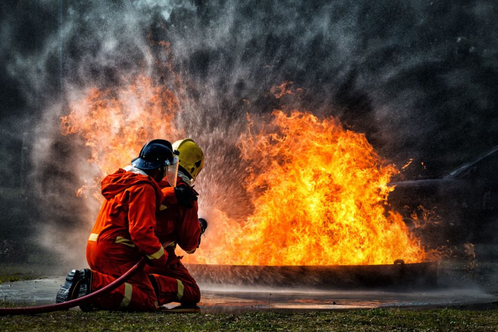 firefighter training., fireman using water and extinguisher to fighting with fire flame in an emergency situation., under danger situation all firemen wearing fire fighter suit for safety.