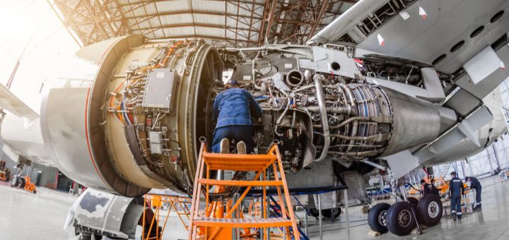 Specialist mechanic repairs the maintenance of a large engine of a passenger aircraft in a hangar