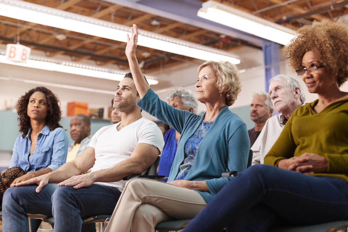 Woman Asking Question At School Meeting; AFT and NEA school reopenings concept