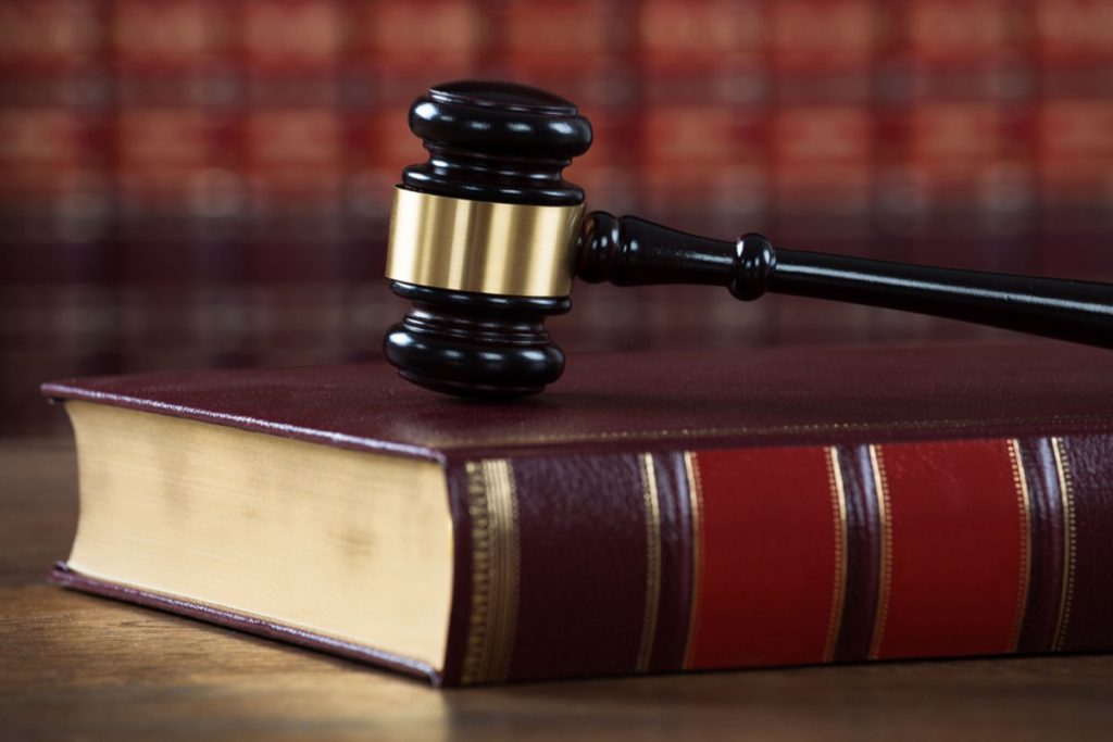 Closeup of mallet on legal book at table in courtroom