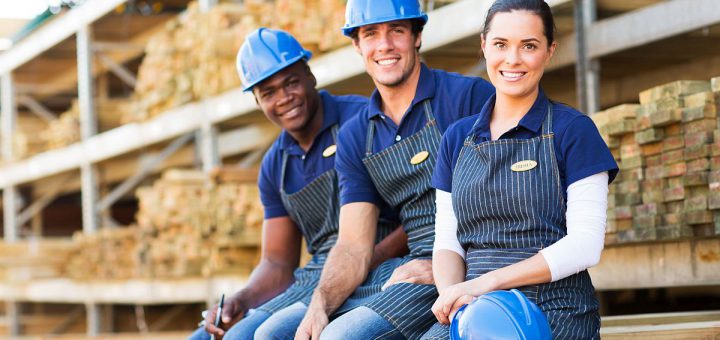 group of cheerful young hardware store co-workers resting at timber yard