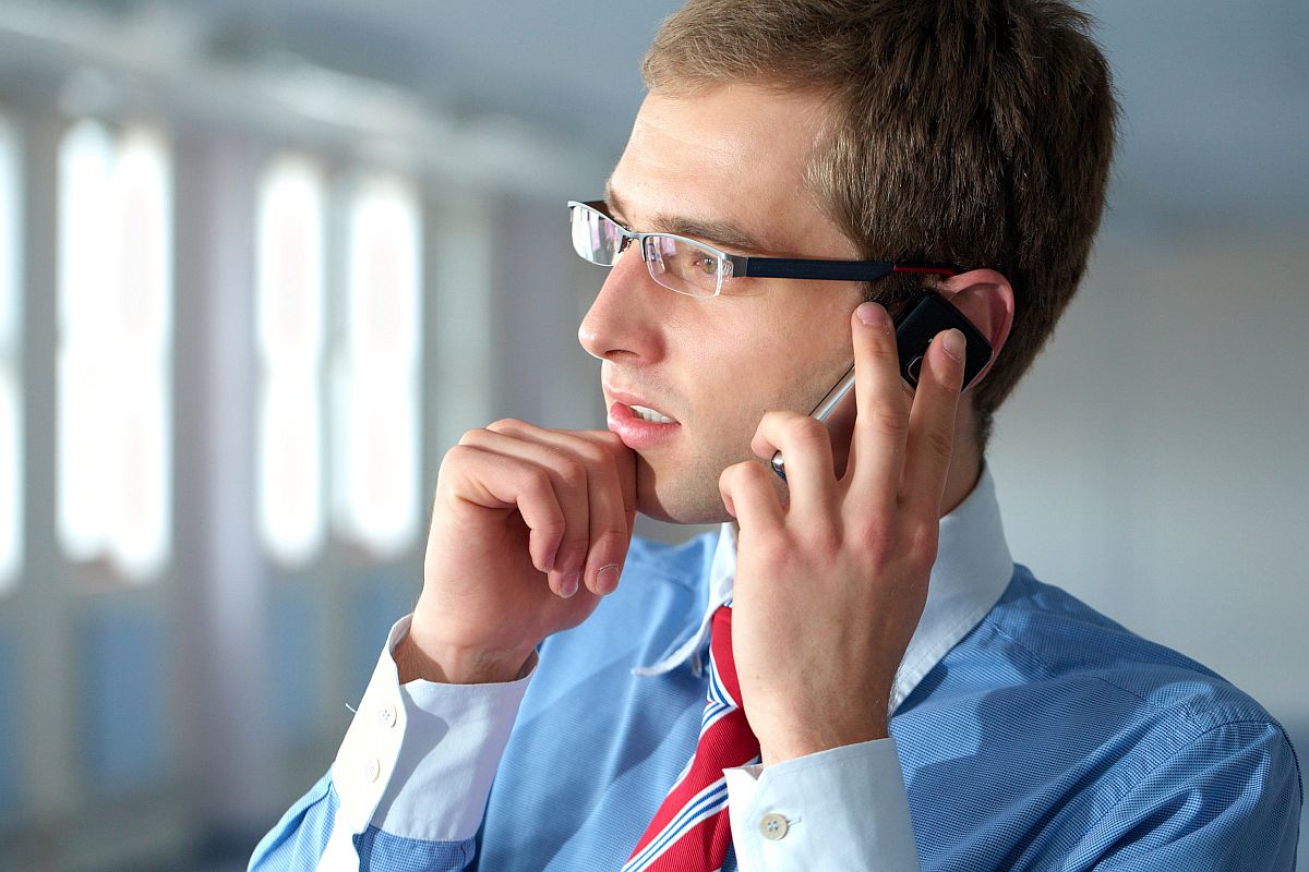 young businessman in blue shirt and red tie talks over mobile phone; finding the right union concept