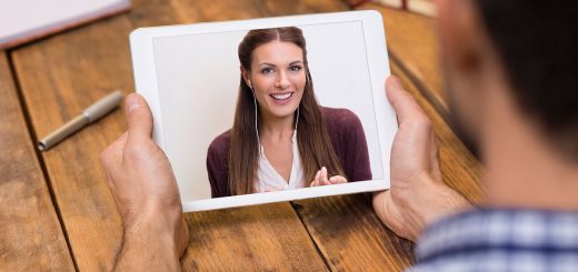 Closeup of a woman talking through video chat on tablet. Young man communicating with his girlfriend on tablet in video chat. Young man looking at screen of tablet and talking with a woman trought webcam.
