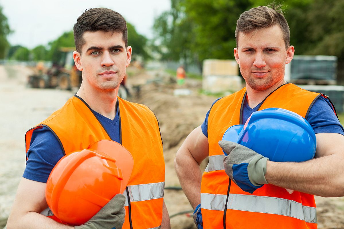 Construction workers holding safety helmets; IIJA and workers concept