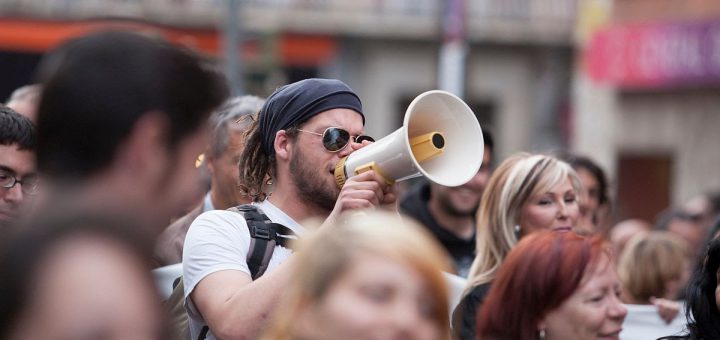 Badajoz, Spain - March 29, 2012: young demostrator with megaphone protesting against austerity cuts, March against the Labor Reform approved by the Government of Spain on March 2012
