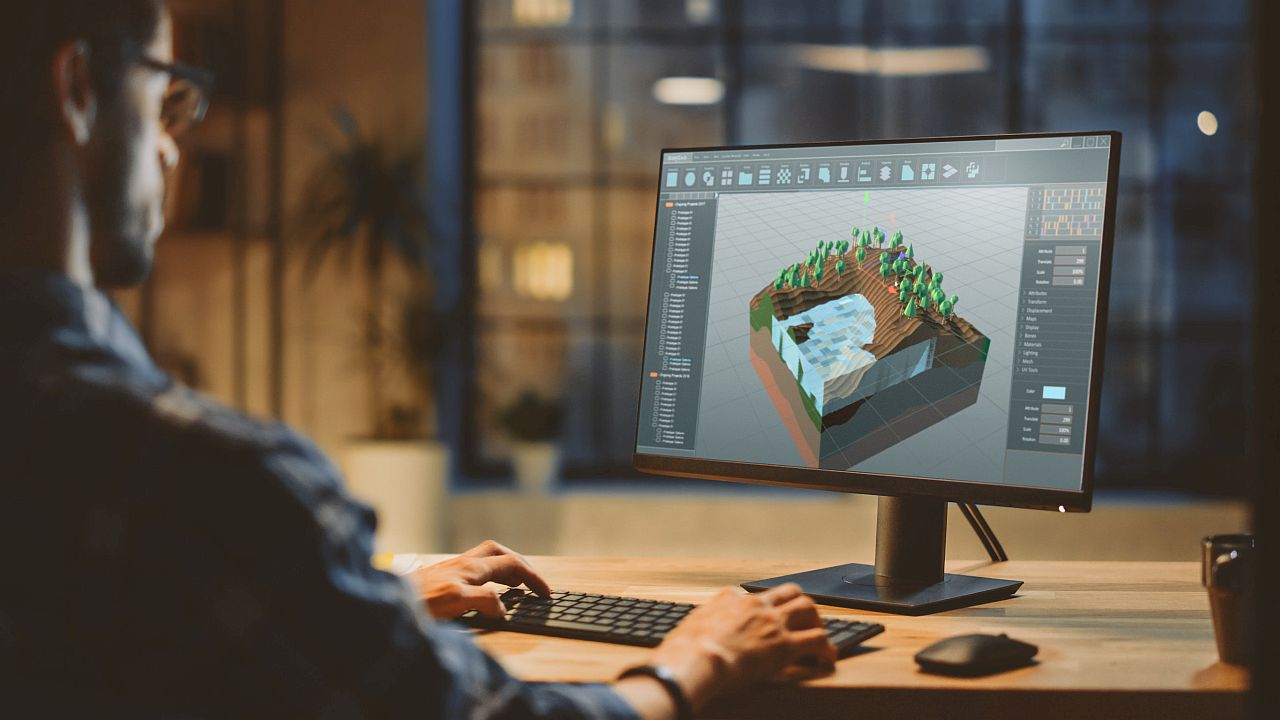 Video Game Developer works on a computer on a 3D level design; recent union drives concept
