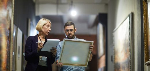 Portrait of two museum workers inspecting paintings; recent union drives concept