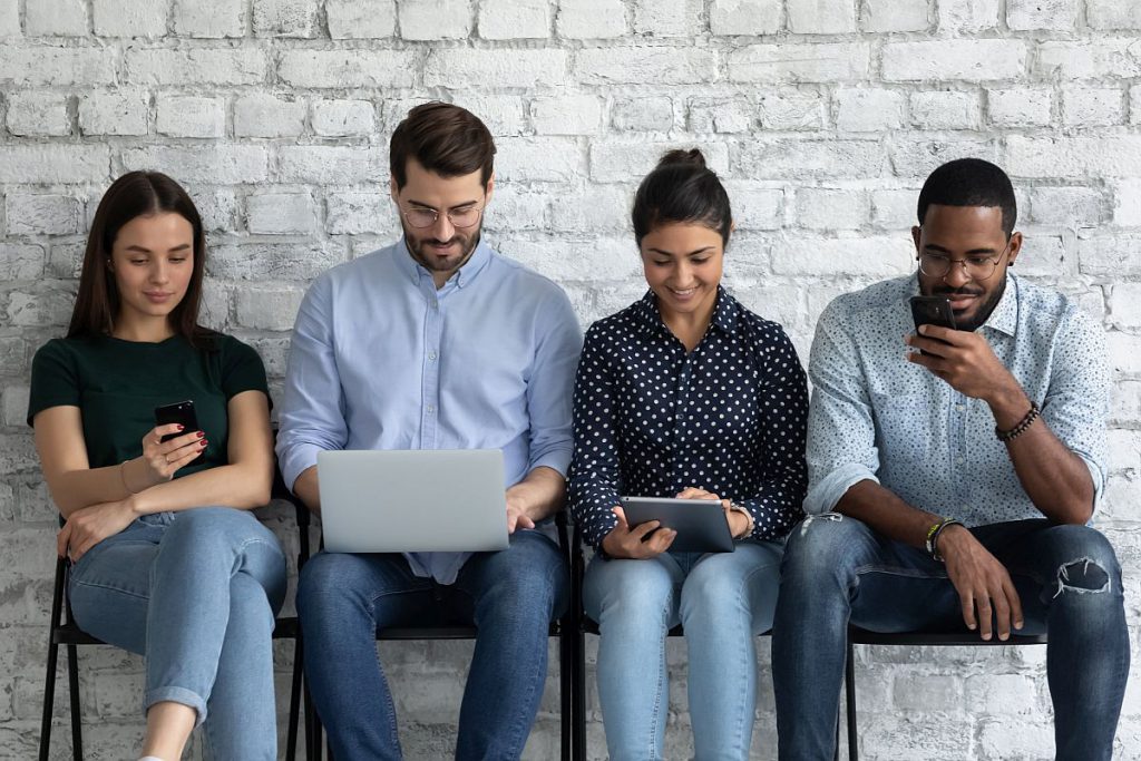 young people sit on chairs indoor with different mobile devices; unions connect with digital natives concept