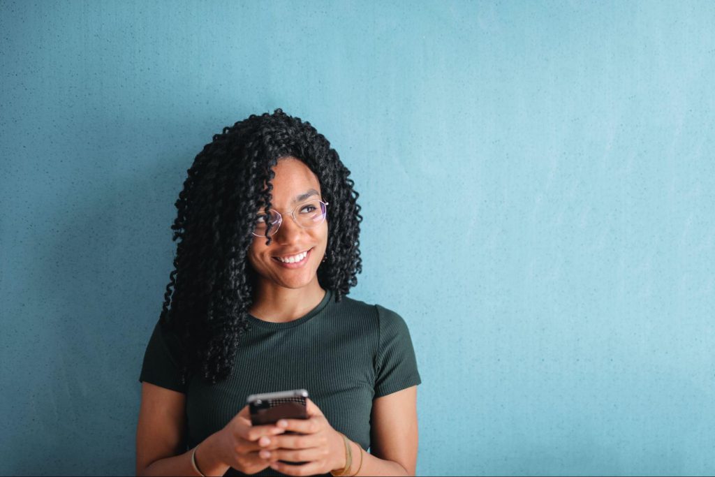 smiling woman using smartphone; informal online spaces concept