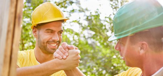 Two workers in hardhats shake hands -- department of labor news