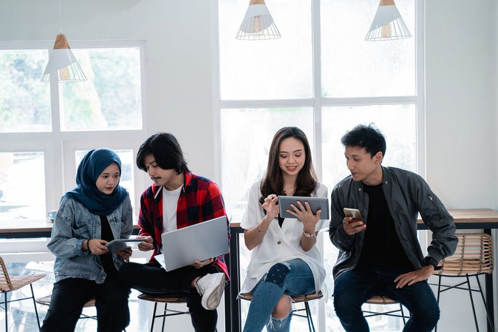 young people in group with laptops and phones; demographics of the new labor movement concept