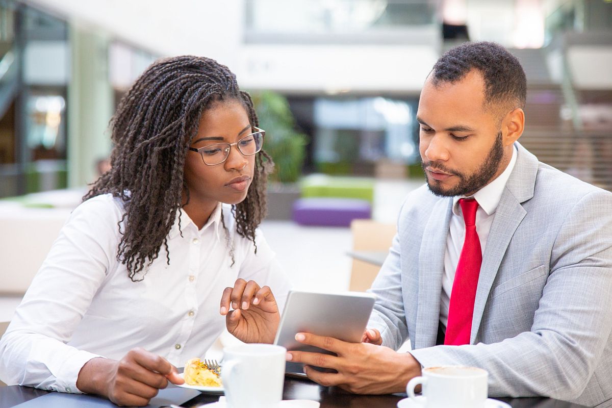 Professional man and woman looking at tablet; unions working together concept