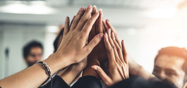 Group of people giving high-fives; unions working together concept