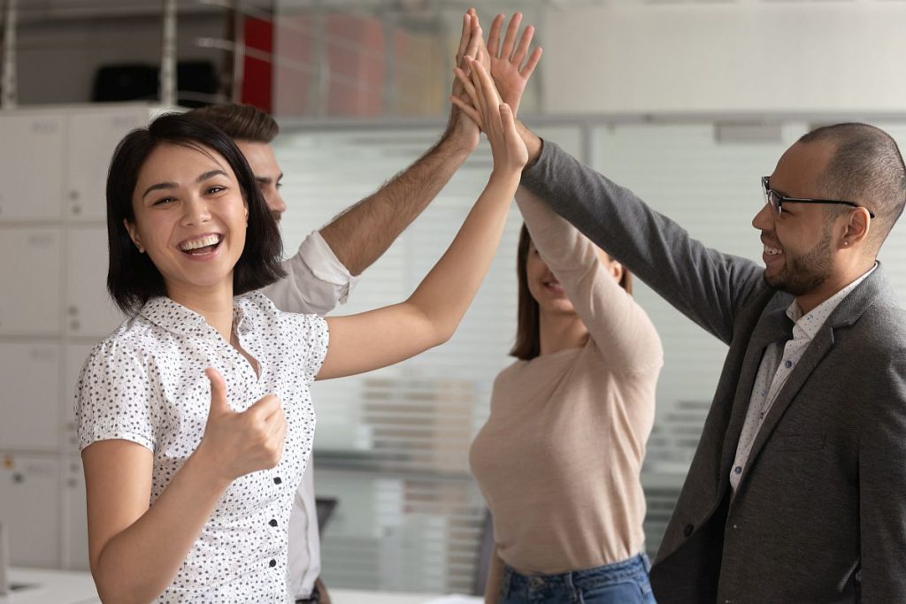 Group of happy people in office setting high-fiving each other; union victories concept