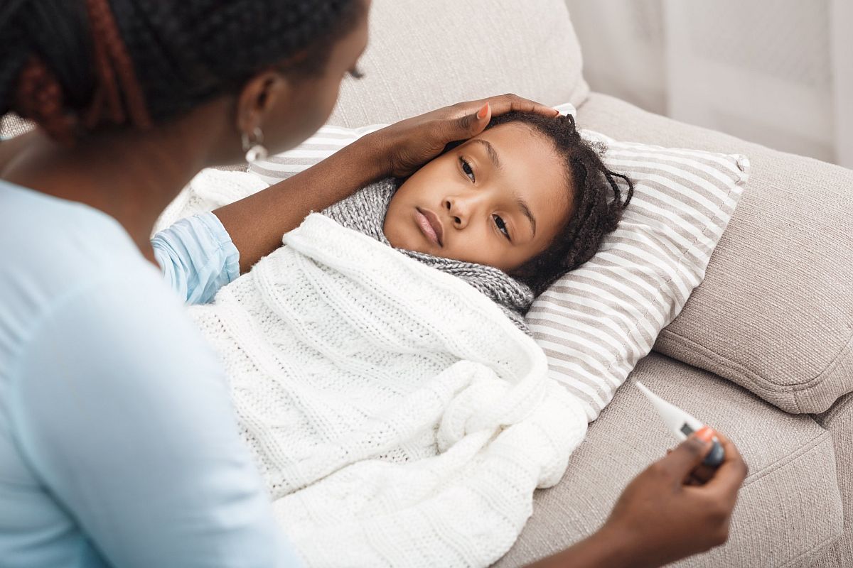 Adult checking child's temperature; family benefits concept