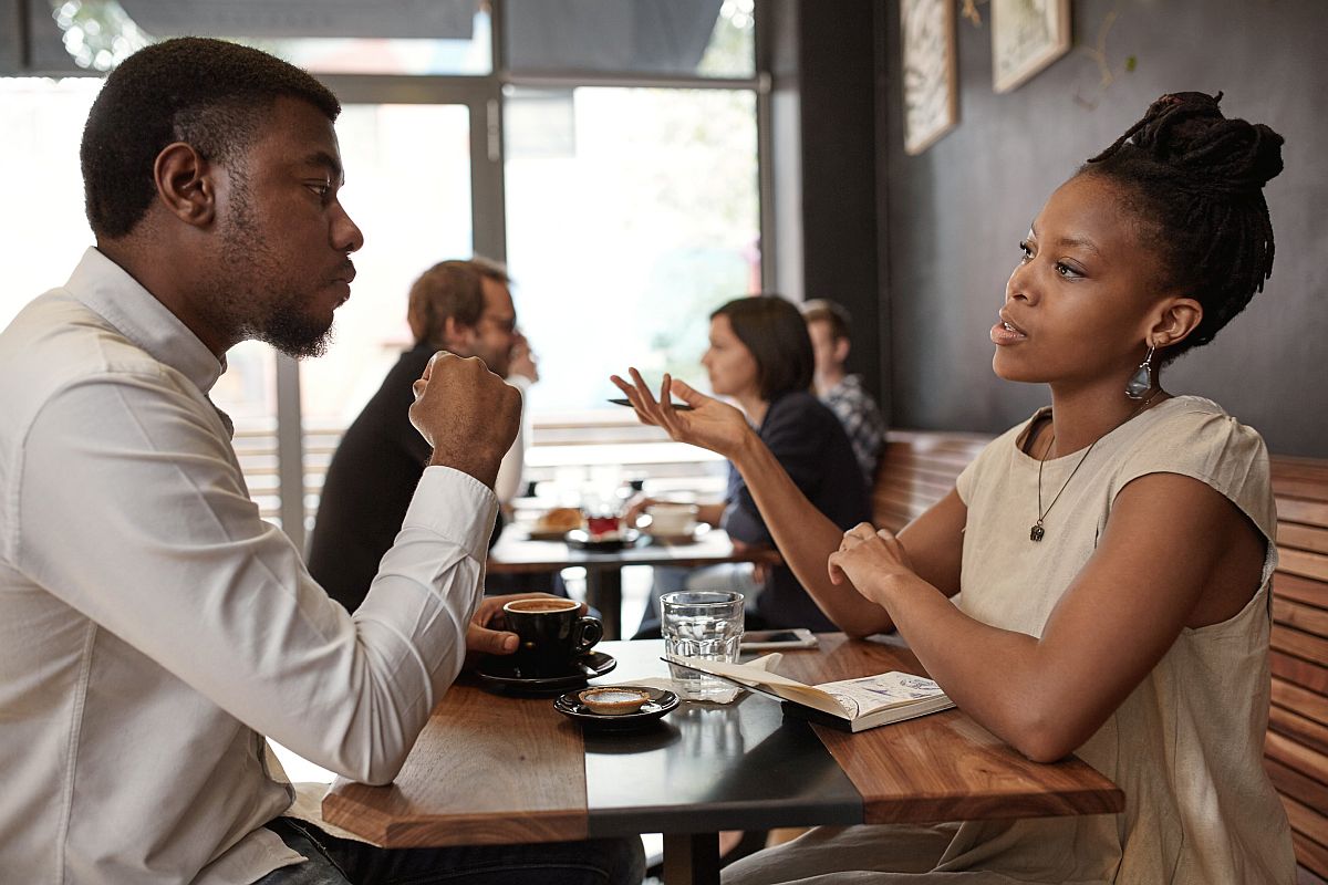 Man and woman having a conversation in a restaurant; union dues concept