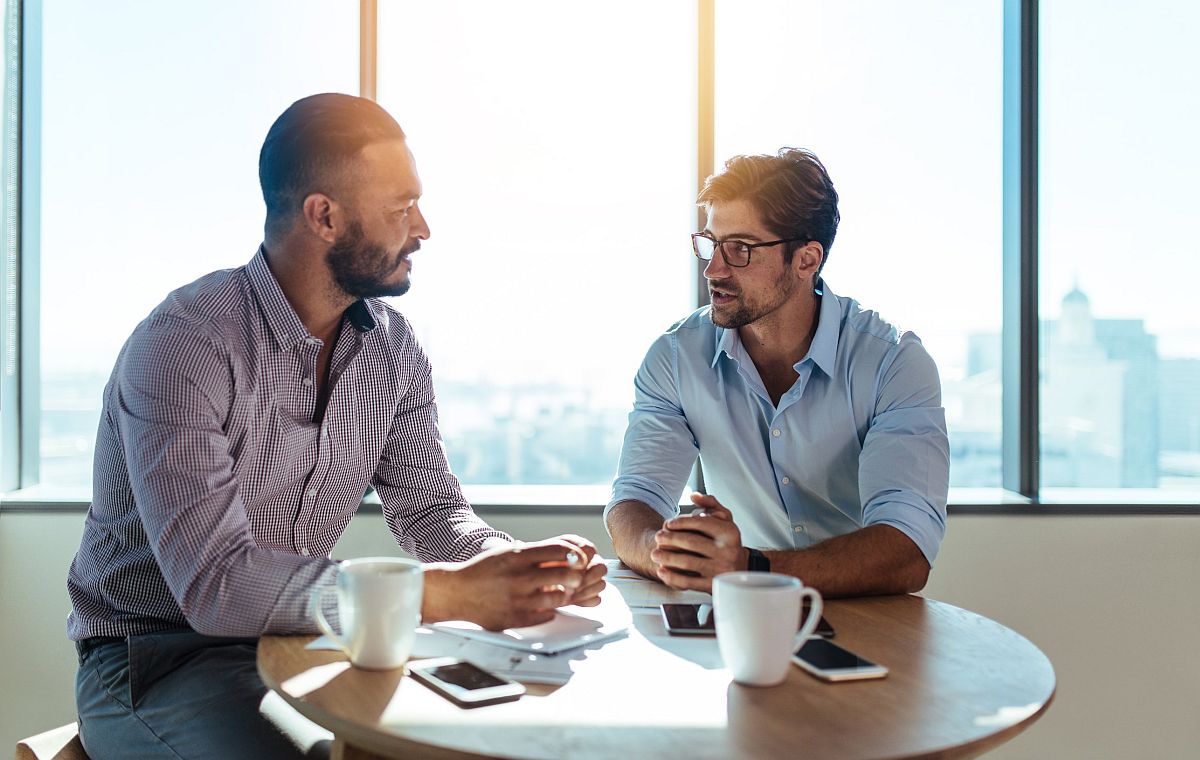 Two professional men talking at table; strong union membership concept