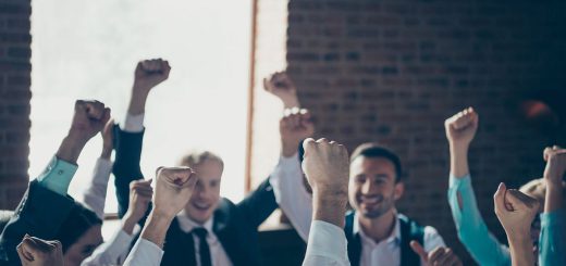 Group of professionals celebrating, with fists in the air; union dues concept