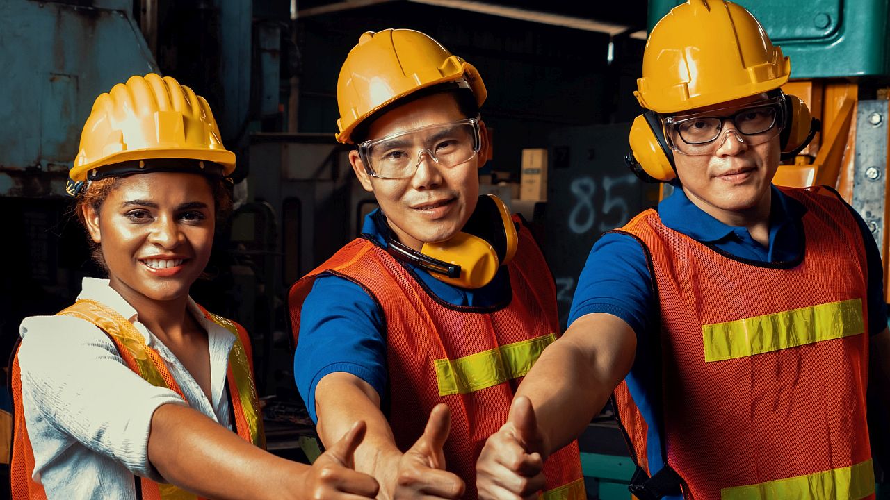 Workers in hardhats and vests give a thumbs up; pro-union nation concept