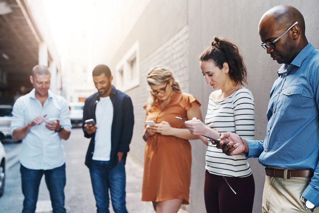 Group of people looking at their phones; social media concept
