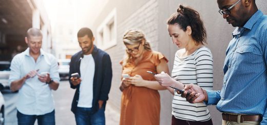 Group of people looking at their phones; social media concept