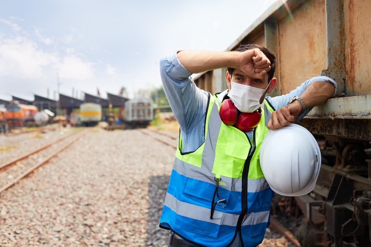 Worried-looking railway worker in yard; preventable accident concept