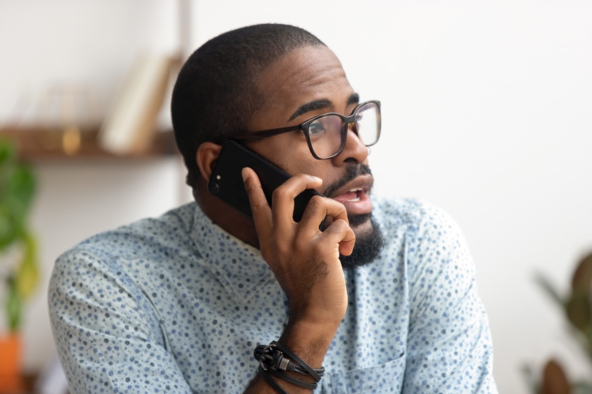 Man talking on his phone at workplace in office; union organizer concept