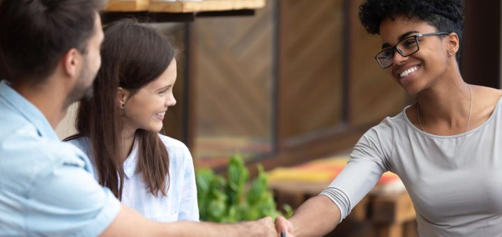 Smiling people at cafe shaking hands; union organizer concept