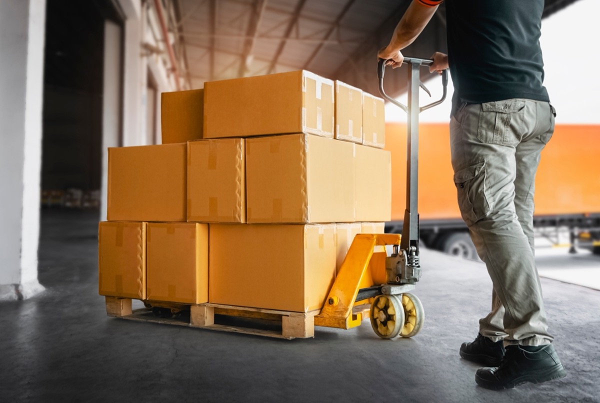 Worker loading boxes in shipping yard; union news federal developments concept