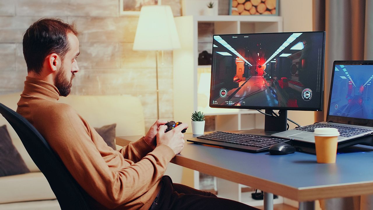 Man testing a video game on his computer; worker wins winter 2023 concept