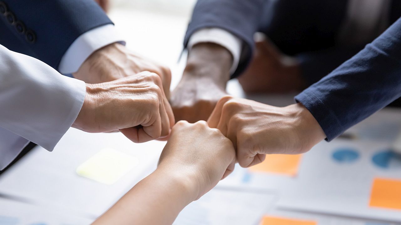 Employees fist bumping; union dues myths concept