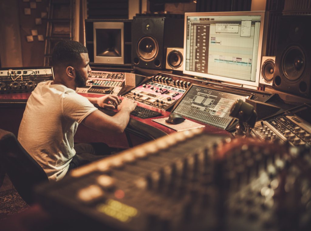 Sound engineer working at mixing panel in boutique recording studio; successful union drives concept