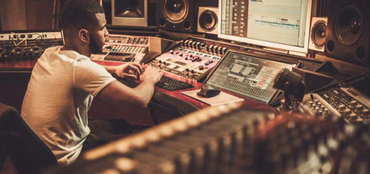 Sound engineer working at mixing panel in boutique recording studio; successful union drives concept