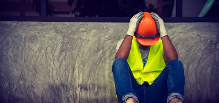 Construction worker sitting head in hands; right to work myth concept