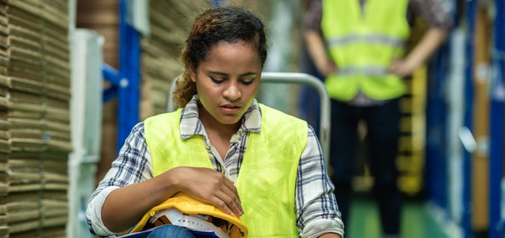 Downcast worker sitting in warehouse; Anti-Labor State Laws concept