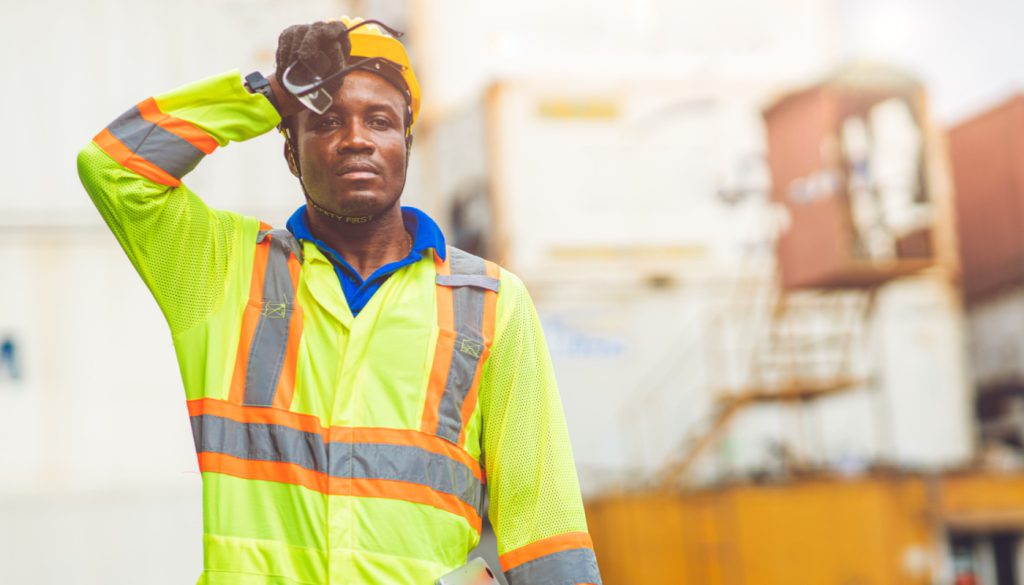 Worker wiping sweat from his brow; Anti-Labor State Laws concept
