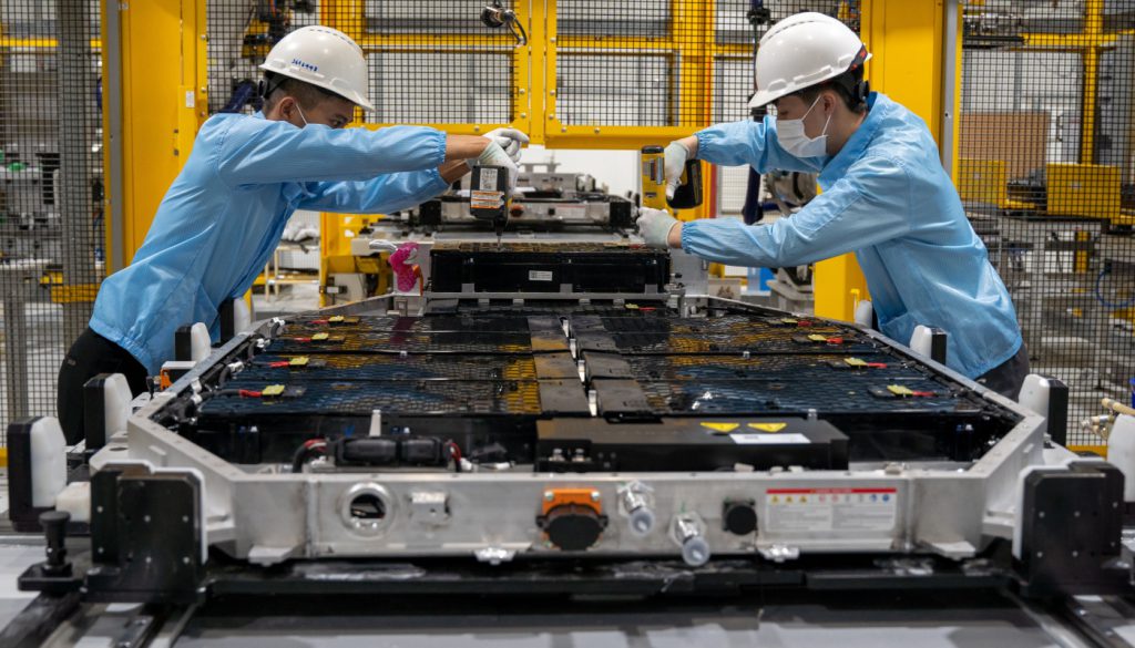 Manufacturing workers in electric vehicle plant; EV transition concept