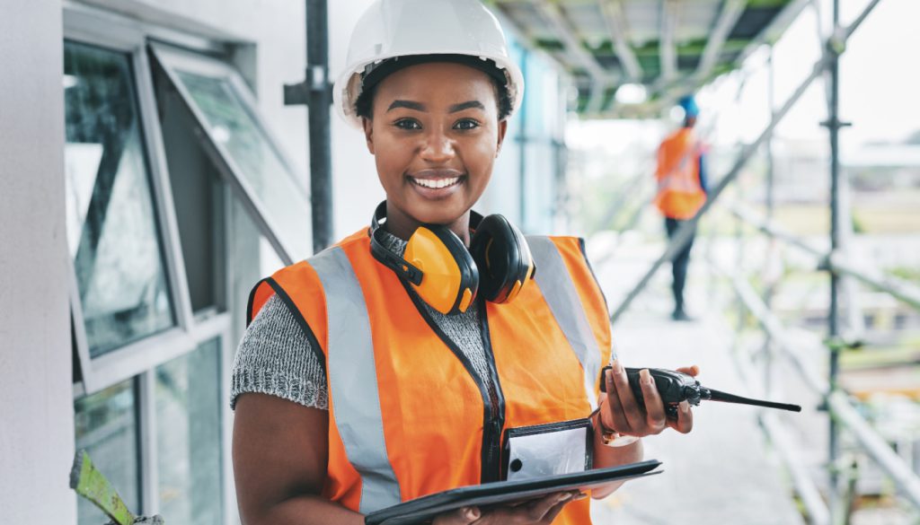 Smiling worker on construction site; workplace protection concept