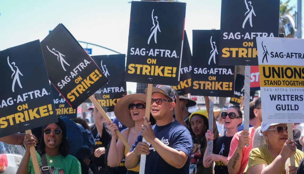 Striking writers and actors picketing; worker solidarity concept